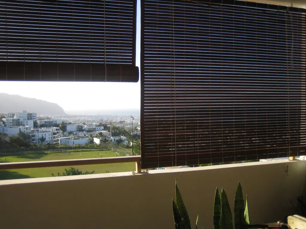 Stores mauriciens en bois de méranti teinte teck sur une terrasse d'appartement a st denis réunion