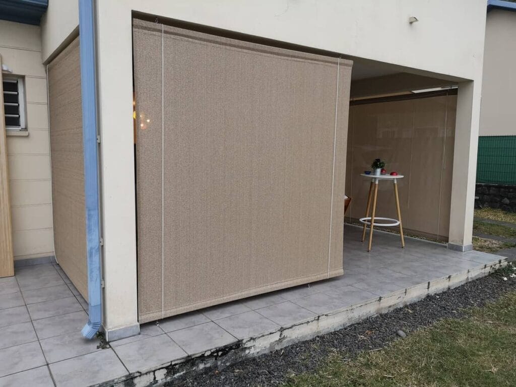 Store voile en toile beige fermant un préau