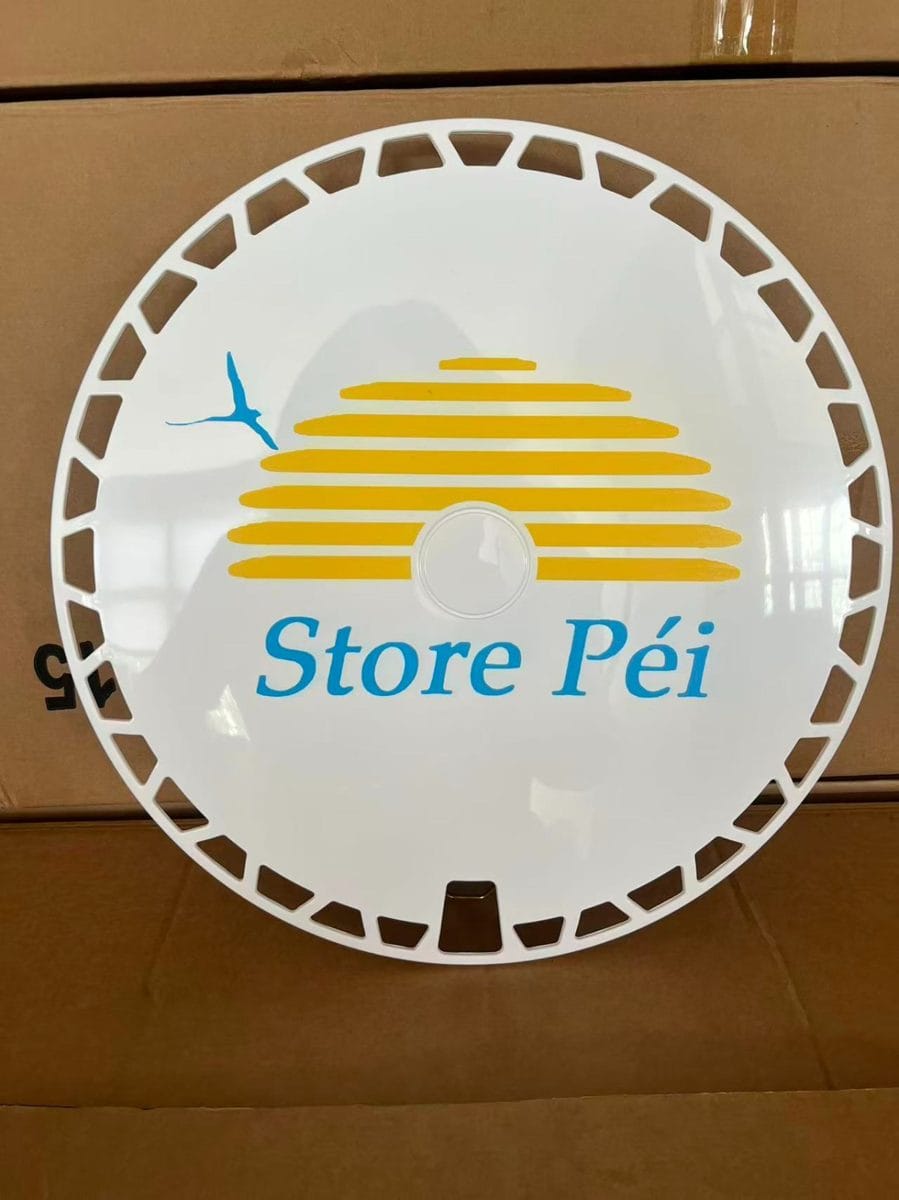 Enjoliveur Store Péi posé sur son carton d'expédition, taille 15 pouces