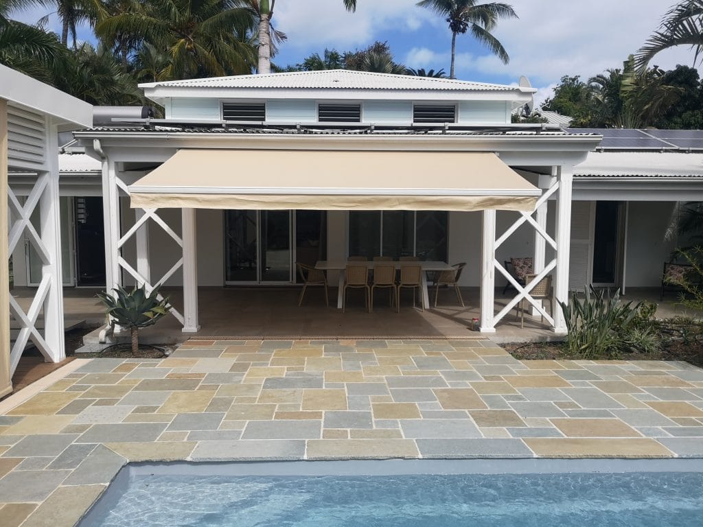 Store banne déployé sur la varangue d'une villa créole avec piscine à La Réunion