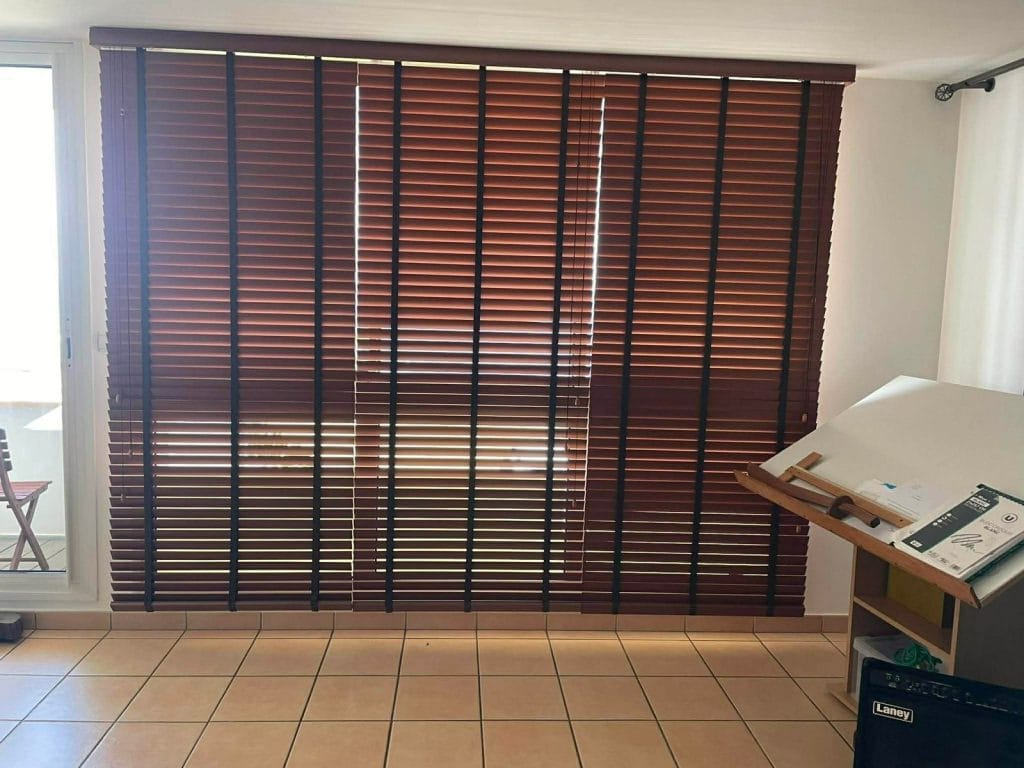 Store vénitien bois 50 mm fermé sur une grande baie vitrée — séjour, La Réunion